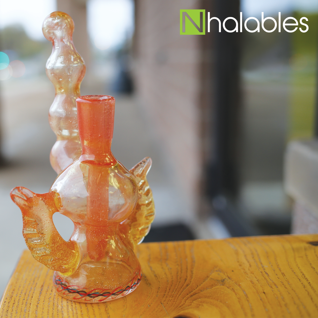 Nhalables Social Post showing a Orange Oil Rig with Feathers on the side by Grover Glass.  Sitting on a wooden bench.