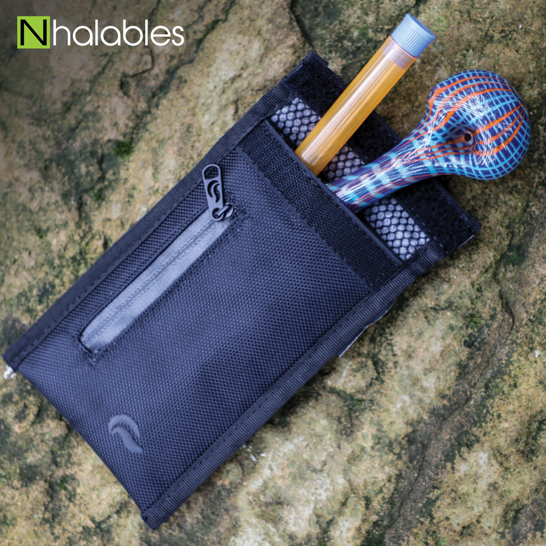 Nhalables Social Post showing a Skunk Bags Smell Proof Travel Pouch with a Color Stitched Handpipe by Hoffman Glass and a Orange Doob Tube Sitting on a Rock 