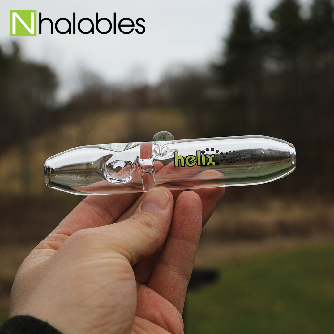 Nhalables Social Post showing a American Helix Uno Steamroller Hand Pipe being held in a hand with some trees behind it