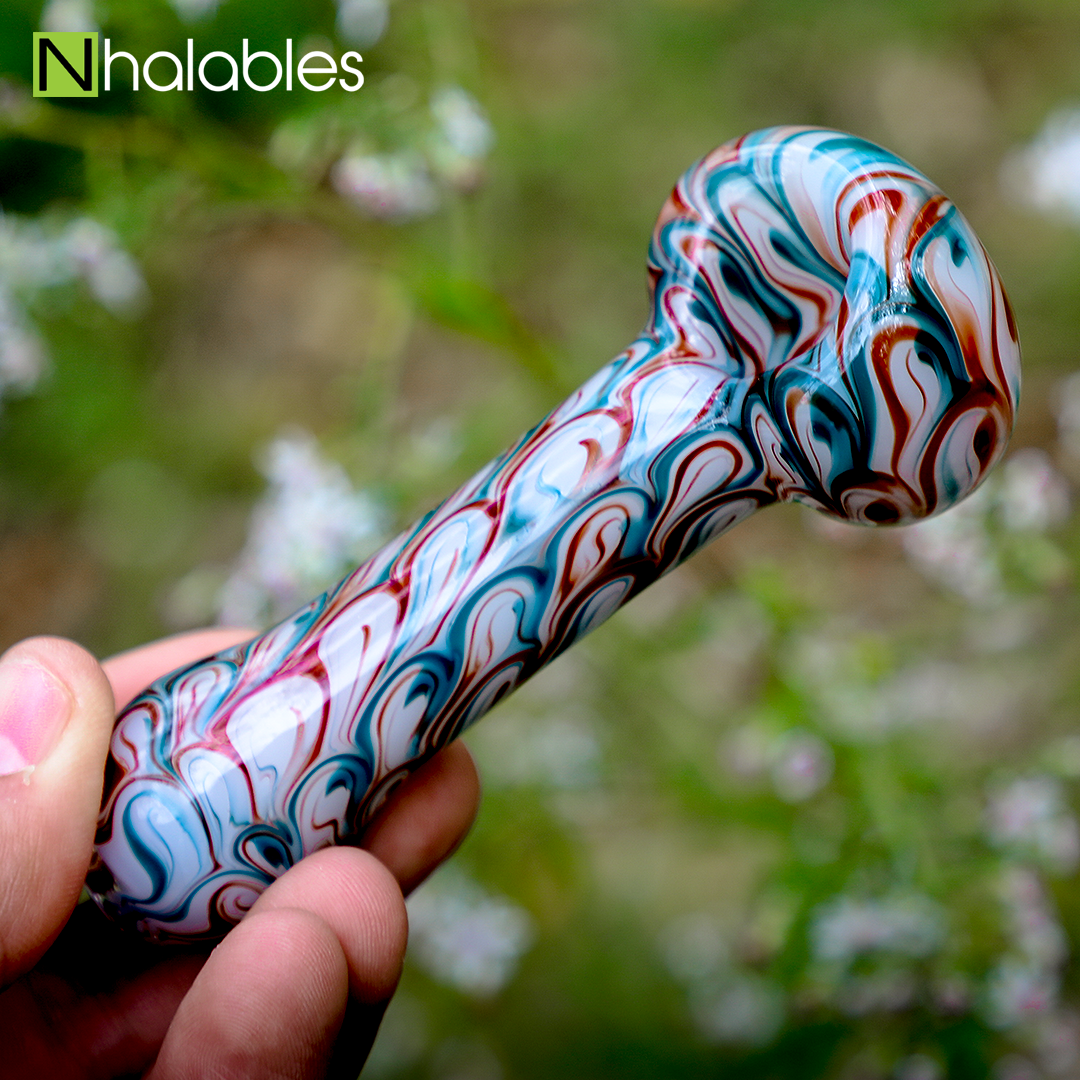 Nhalables Social post showing a non sanblasted handpipe by New York based "Izlow Glass" in front of some blurry flowers