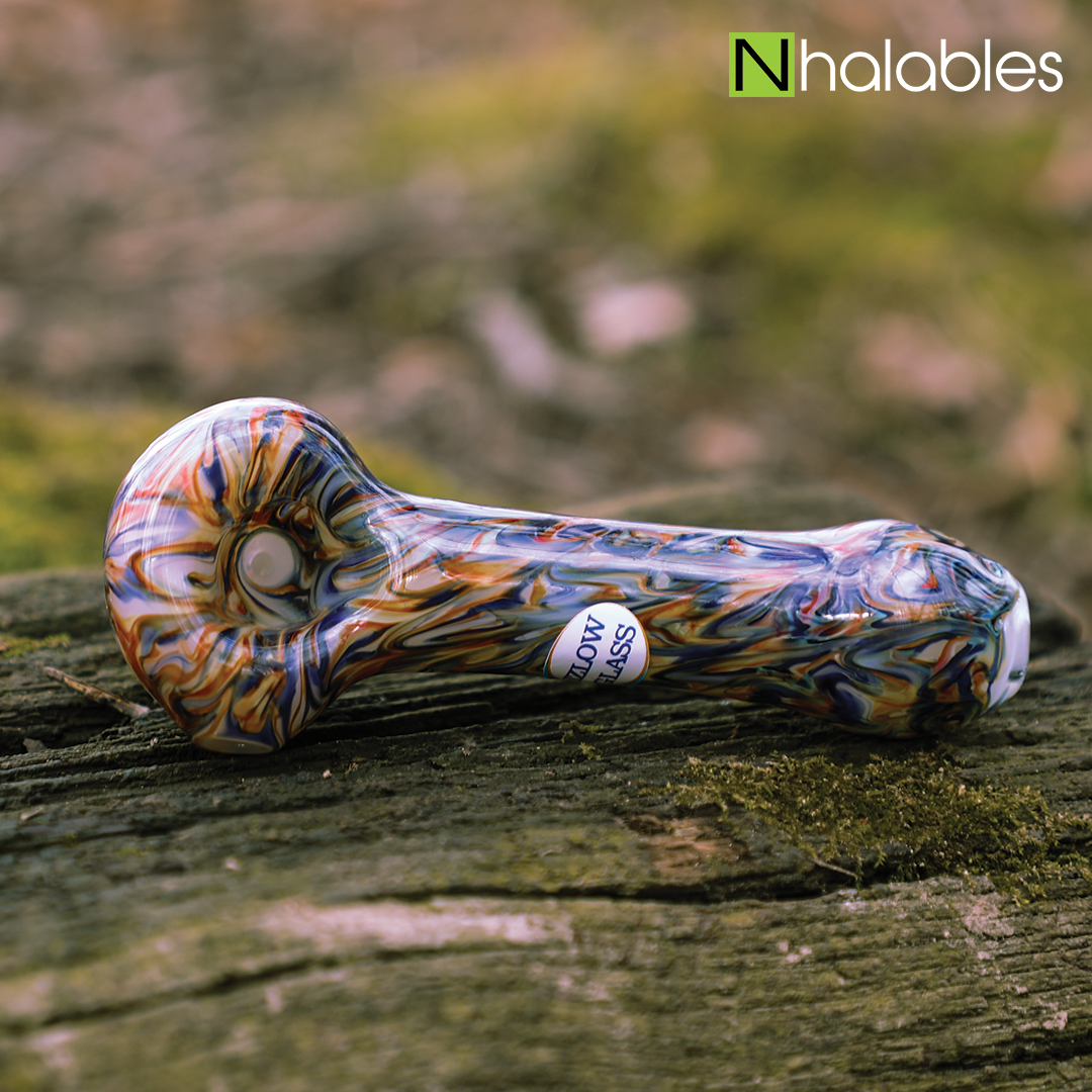 Nhalables Social Post showing a orange and Blue Hand Pipe by New York based  Izlow Glass sitting on a log with some blue grass in the background