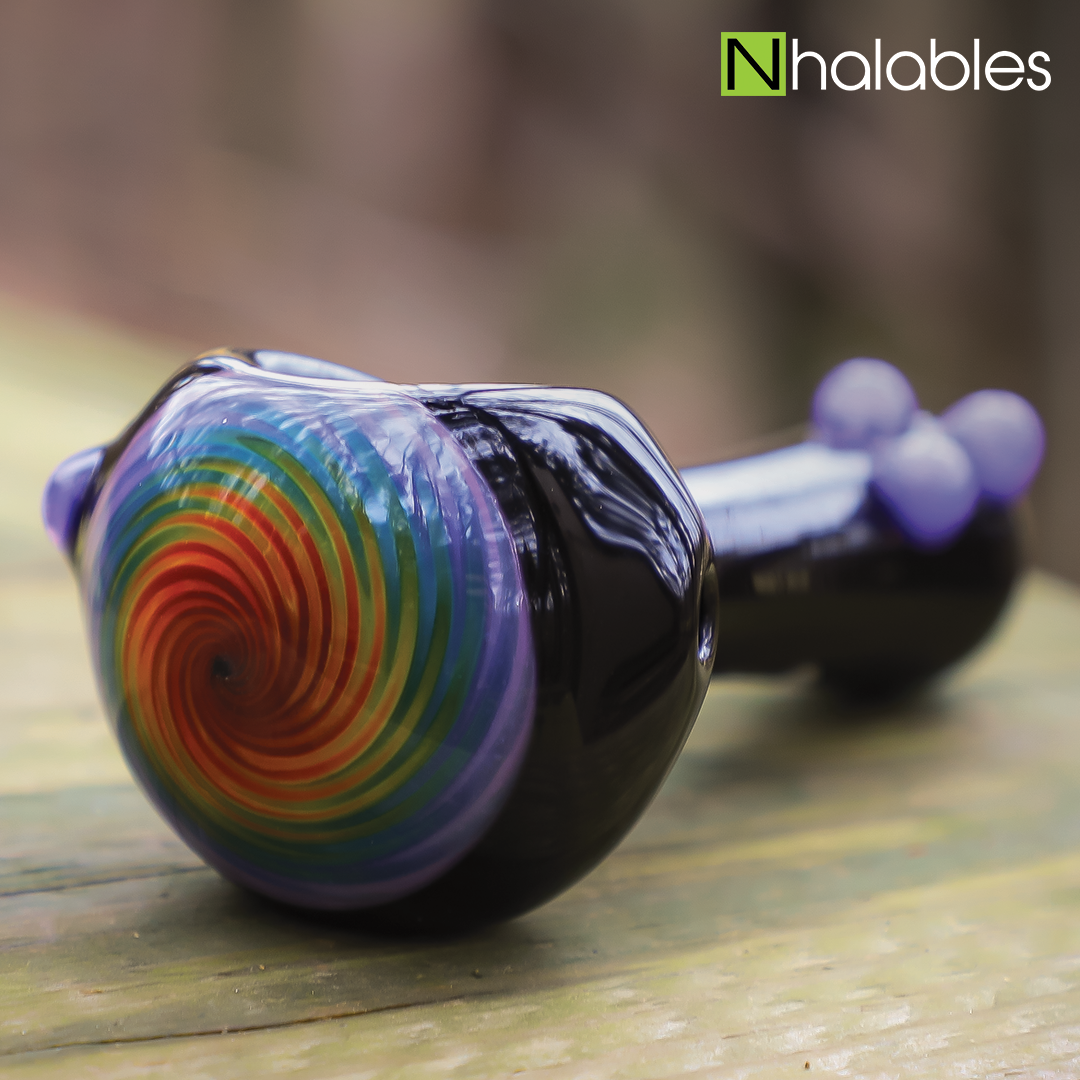 Nhalables Social Post showing a Black Rainbow cap spoon sitting on a wood step with blurry trees in the background.