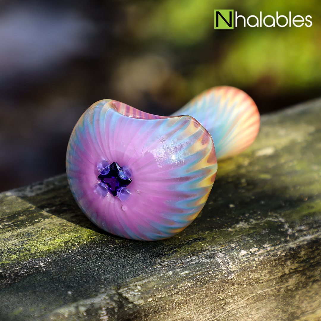 Nhalables Social Post for a Collection of Hand Pipes by Michigan based artist White Chocolate Glass (rainbow hand pipe laying on a wooden railing)