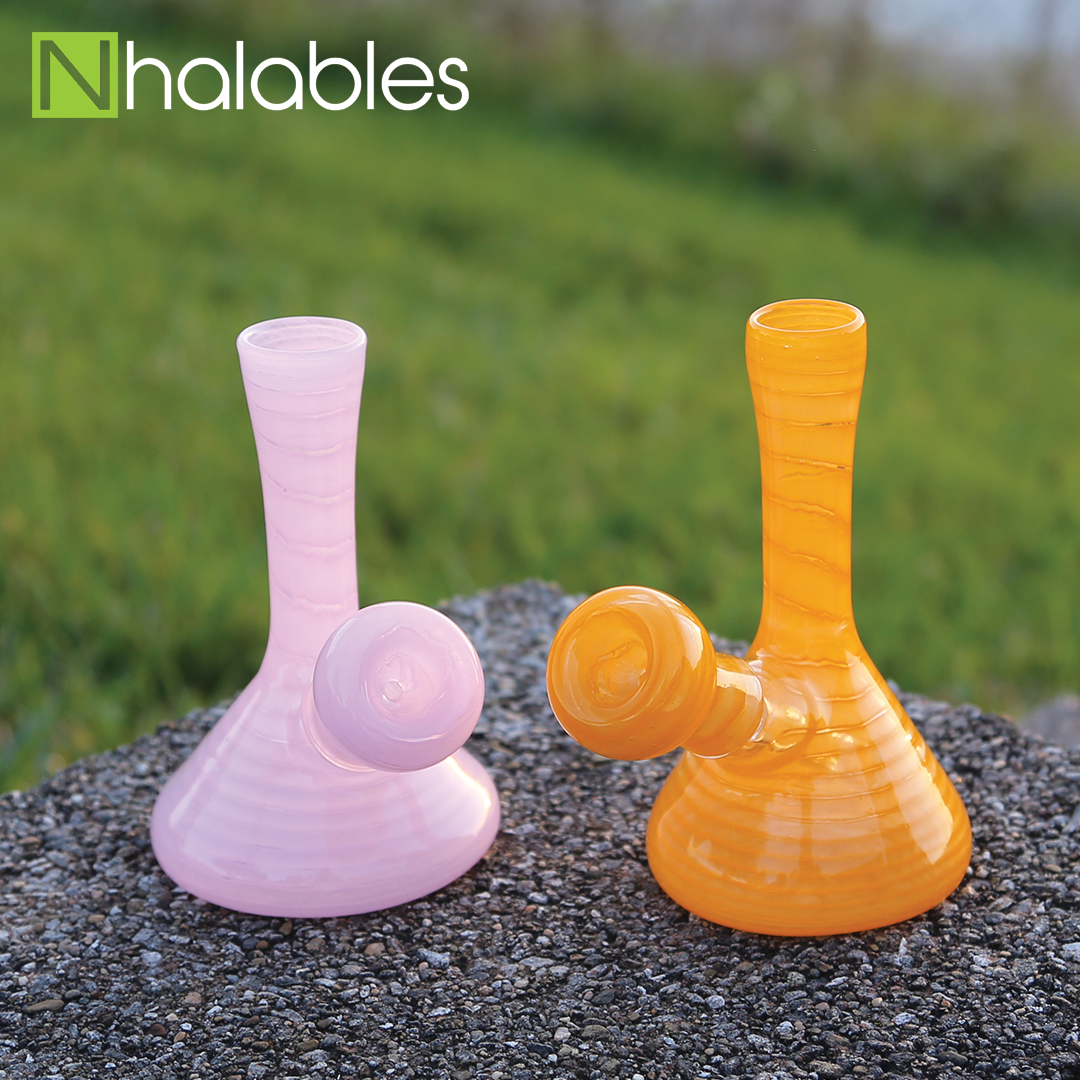 Nhalables Social Post showing a yellow and a pink minitube sitting ona concrete rock with grass in the background.