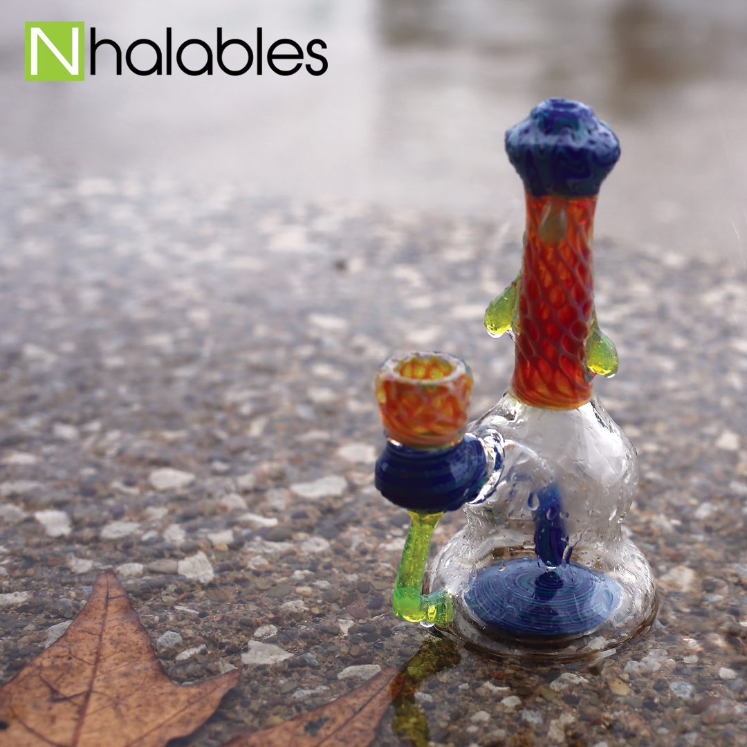 Nhalables Social Post showing Kentucky based artist Plug a Nug honeycomb banger hanger sitting on the asphalt in the rain.